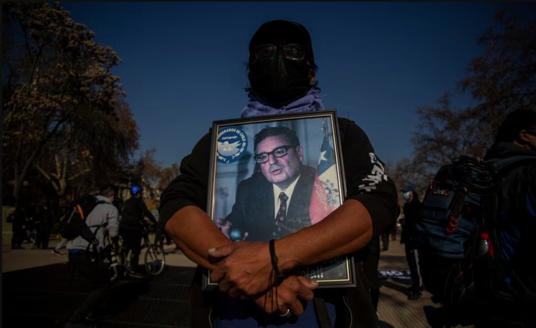un manifestante chileno sostiene la foto de salvador allende